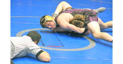 Lumpkin County wrestler Levi Seabolt pushes his opponents shoulders to the mat for a win by pin.