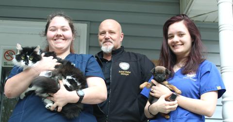 Lumpkin County Animal Shelter staff workers are, from left, Aaron Taylor, holding Slim, Wayne Marshall and Savana Scheidt, holding Pup.