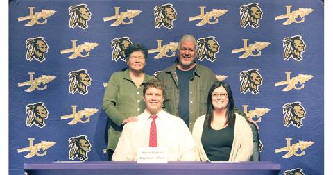 LCHS football player Aaron Hopkins celebrates another four years of football with his mother (back left) Sally Hopkins, his father (back right) Michael Hopkins and his sister (front right) Kelsey Hopkins during a signing ceremony held at the LCHS auditorium recently.