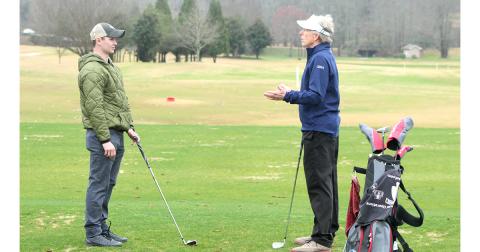 Adaptive Golf Program participant Chris Marshall receives advice on how to improve his swing from golf enthusiast and program volunteer Ken Taylor.