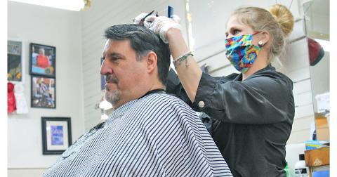 Mark Evans arrived early on Monday morning to get his first post-quarantine haircut at Woody's Barbershop. Mandi Borland was one of only two barbers to work the first day the barbershop was re-opened.