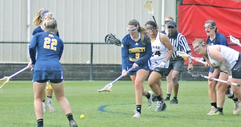 Holly Foster scoops up the ball for the Truett McConnell University Lady Bears. She and her sister Hope have made quite the mark on collegiate lacrosse fields since they learned how to play the game two years ago.