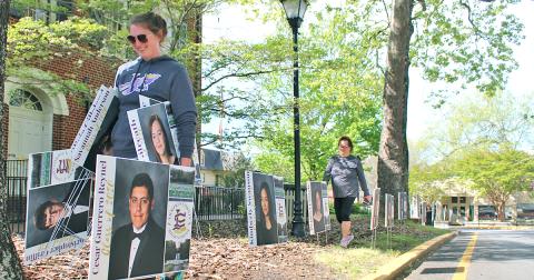 Lumpkin County High School assistant principal Whittney McPherson carries senior signs as she and other LCHS faculty members placed the signs along downtown Dahlonega to honor the Class of 2020. 