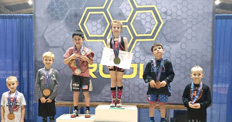 Allie Procter stands on top of the podium after winning her third straight Youth Georgia Wrestling State Championship title recently. Procter, 8, racked up three wins by pin versus her male opponents to secure her third straight championship title.