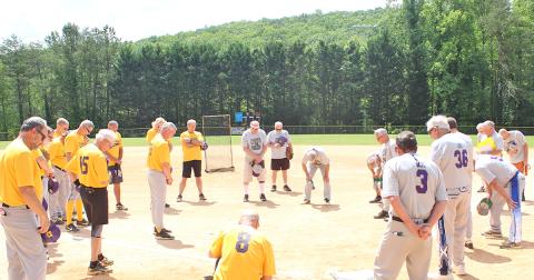 Members of Lumpkin County’s two senior softball teams, the LC Miners and the Dahlonega Gold, take a moment for prayer before playing their first game since last season after the coronavirus pandemic delayed the start of their season. All players were thankful to be back on the diamond after the long hiatus.