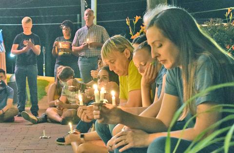ABOVE: A crowd of community members, including Patti Wright (foreground), gathered downtown Sunday evening for a race-related prayer vigil in front of Canopy+Roots.