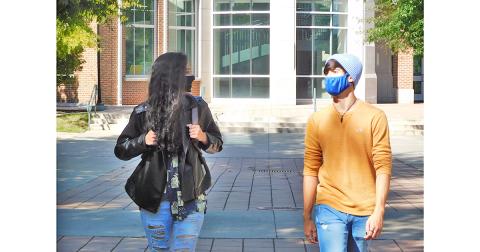 Michaela Follett and Chris Potter mask up and walk to class at the University of North Georgia. The local students weren’t  pleased to hear that their Spring Break has been cancelled for the year.