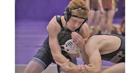 Freshman Austin Marshall tries to control the head of his opponent during his 132 lb matchup against Lambert High School. 