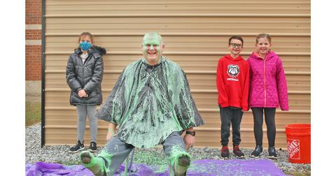Long Branch SRO Nick Parrish was slimed in celebration of exceeding the school's original fundraising goal, much to the pleasure of LBES students (from left) Ellie Flynt, Micah Smith and Briley Seabolt.