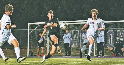Senior Dylan Bodney sends the ball between multiple Dawson County defenders on the attacking end during the team’s Senior Night victory over the Tigers. Bodney scored one of three goals.