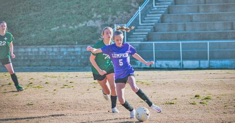 Middle school player Kaitlyn Johnson controls the ball and looks to create a play out wide.