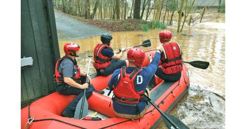 The Lumpkin County Swiftwater Rescue Team, including, from left, Chris Maloney, Derrick Haney, Eric Wimpy and Brennan Powell prepare to launch into the flood swollen waters at Golden Avenue. (Photo courtesy of David Wimpy)