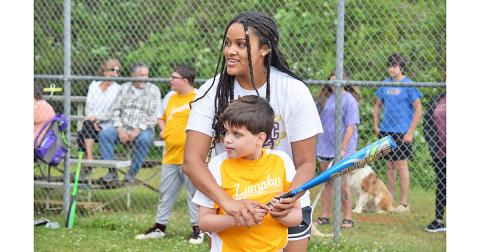 Luca Diamante and Kate Jackson, who await a pitch from Bob Burrell as Susan Burrell (not pictured) coaches from the backstop. 