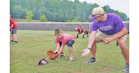 LCHS alum and LCMS Baseball Coach Daniel McCrary (right) shows Kason Dehne the proper ready position as an infielder preparing to field the ball during the Lil’ Indians Baseball Camp held at the high school last week.