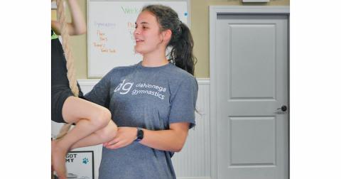 Julia Lancaster helps a student climb a rope at Dahlonega School of Gymnastics, where she teaches 5 and 6 year olds.