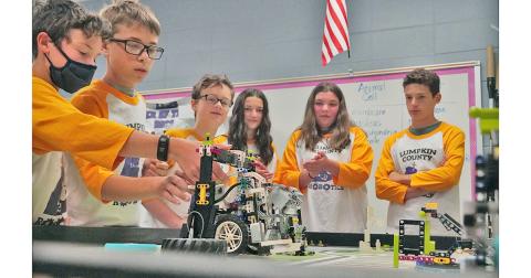 The members of the LCMS LEGO's team watch as Mathieu Weber (left) makes adjustments to the team's robot as it completes tasks as it did when the team won the FIRST LEGO League Tennessee Valley/North Georgia Region Championship in April.