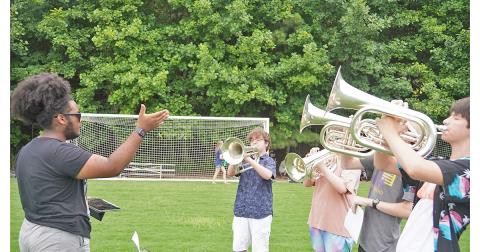 One of last season’s Drum Majors, Najja Hughey, conducts a group of brass players as they practice their 2021 Halftime Show. Hughey was one of several former band leaders that director Andrew Harwood had come back to help with instruction for this year’s Band Camp.