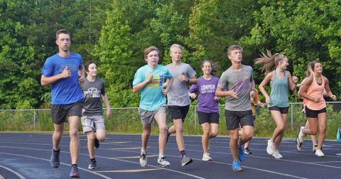 New LCHS Cross Country Head Coach Logan Turner, left, runs alongside his team during a recent summer workout. Turner says he's excited about the new role and the ability to have positive impact on kids' lives.