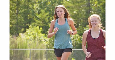 Abbie Hilchie (left) and Kelly Cronan, get warmed up during a recent practice. Hilchie led the way for the girls during their first meet on Thursday, taking fifth overall with a time of 23:15 to help push her team to fourth place at the meet.