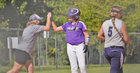 Head coach Brooke Grindle celebrates with Riley Dyer after she knocked in two runs with a double before advancing to third to give the Indians a 6-2 lead in the first inning.