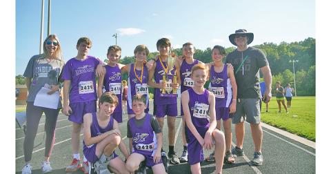 The LCMS boys cross country team celebrates with the trophy after claiming their second first-place finish of the season with five runners finishing in the top 15 of the event.