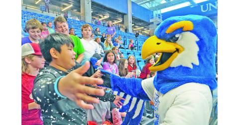 Justin Morales Soriano goes in for a hug with Nigel the Nighthawk, UNG's mascot, while friends (from left) Cooper McKee, Nathan Hester, Maddox Davis and Ethan Richards watch and laugh along.