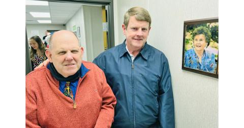 David (left) and Eddie Green stand beside a plaque honoring their late mother, Anne, for whom the new clinic is named. She was one of the free clinic’s most ardent supporters from the beginning, whose idea of holding a tomato sandwich supper became its signature fundraiser each year.