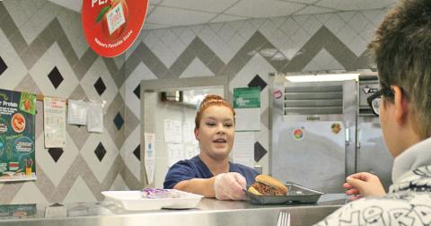 School nutrition specialist Sarah Vincze prepares a barbecue sandwich for a student at Lumpkin County High School.