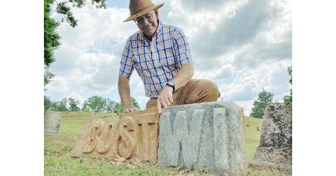 Local historian Chris Worick examines some mysterious stone letters found recently in Dahlonega’s Mount Hope Cemetery.