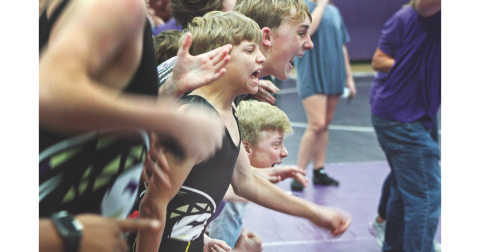 Middle school wrestlers Liam Nielson, Caleb Soles, and Alexander Nielson cheer on one of their teammates during the Lumpkin County match at Clear Creek last week.