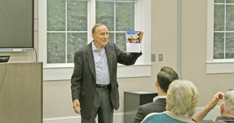 Senator Bud Stumbaugh holds up a copy of his inspirational book "Do the Best You Can’t!" during an Authors in the Afternoon event at the Lumpkin County Library. The book is available on Amazon and other online retailers.