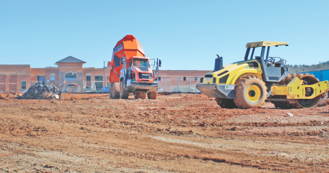 Construction vehicles mobilize in front of Cottrell Elementary, near the future site of the new recreation center.