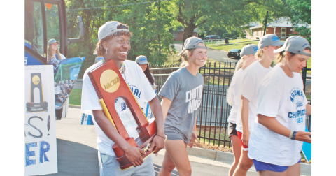 Reacting to the crowd of fans who had gathered in Dahlonega, UNG outfielder Mariah Wicker proudly holds the NCAA Division II Softball National Championship trophy as the Nighthawks return home. Once the bus arrived from Chattanooga, the team was enthusiastically greeted at their home stadium a few hours after winning the title. (photo by Keith Murden / The Nugget)