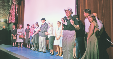 Holly Theatre Chairman Emerita Ivana Pelnar-Zaiko explained the rules of the audience-judged 1940s costume contest prior to the start of the movie.