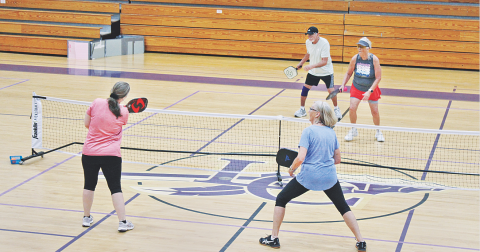 Pickleball players (foreground, from left) Tracie Grizzle and Sally Trapnell face off against the team of (background, from left) Dennis Weinman and Phyllis Gailey on an indoor court at Lumpkin County Parks & Rec.