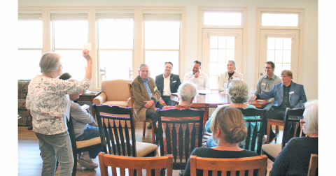 Summit Forum moderator Mary Lasris holds up a time card showing 30 seconds remaining. Seated at the table (from left) are Dahlonega City Council candidates Tom Gordineer, Lance Bagley, James Guy, Melanie Dunlap, Dan Brown and Johnny Ariemma.