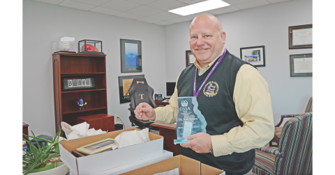 Dr. Rob Brown carefully packs his keepsakes in preparation for his retirement as Lumpkin’s superintendent.