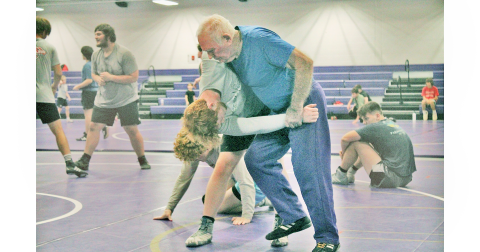 Ed Wright assists Jacob Pricer during one of the team’s practices.