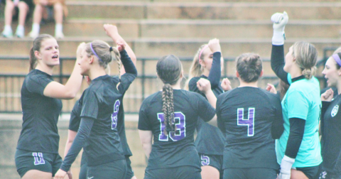 The lady Indians soccer team huddles together before storming the field.