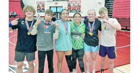 Lumpkin wrestlers Nathan Nielsen, Liam Nielsen, Maddie Mendoza, Nattalie Mendoza, Greta Garbuzovas and Xander Nielsen share a moment at the Warrior Invitational.