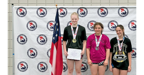 Greta Garbuzovas (left) stands atop the podium at the Southeast Regional Championships.