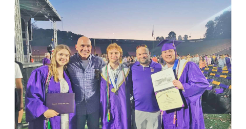 Paisley Thomas, Wrestling Head Coach Sean Hage, Austin Marshall, Assistant Coach David Matthews and Jacob Pricer share a special moment at their graduation ceremony. 