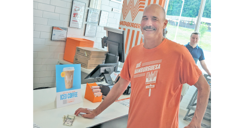 University of North Georgia professor Steve Smith savors his status as the first official customer at the newly opened Whataburger on the corner of Morrison Moore Parkway and Riley Road.