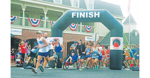 Competitors race out onto the course during the annual Fourth of July Firecracker 5K event.