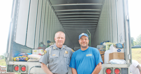 Sheriff Stacy Jarrard and volunteer relief organizer Donald Hupp are pictured in front of their second hurricane supply trailer last Thursday. By Monday, the same trailer was completely filled and headed for a church in Asheville, North Carolina.