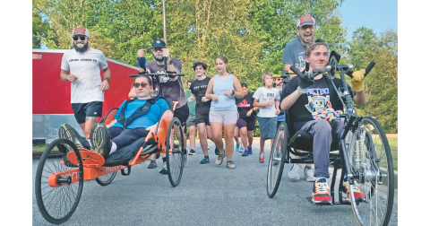 Race for a Reason runners and rollers head out on a recent jog through Yahoola Creek Park as Shari Carpani, seated on left, gets a boost from her running mates, Ben Paddick and David Tate, while Nathan Valencia, seated on right, and James Daniel keep things rolling.
