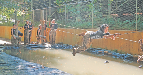 Ru Helvie conquers the commando rope cross during the team’s meet in Heart County.