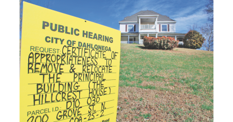 A sign on the lawn of the Hillcrest House notifies the public of a proposal to relocate the historic building. The structure is a well-known landmark to frequent passers-by on North Grove Street.