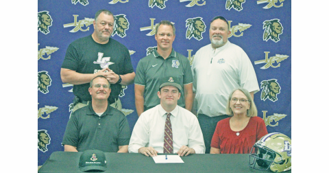 Matthew Reece signs his commmitment surrounded by his coaches and parents.