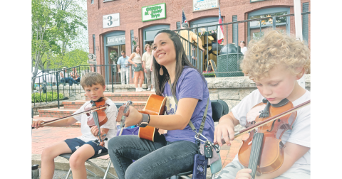 Cottrell Elementary School music teacher Amanda Barton and Georgia Pick & Bow students Emerson Barton, left, and Montgomery Barton add to the musical soundtrack of Bear on the Square on Sunday.